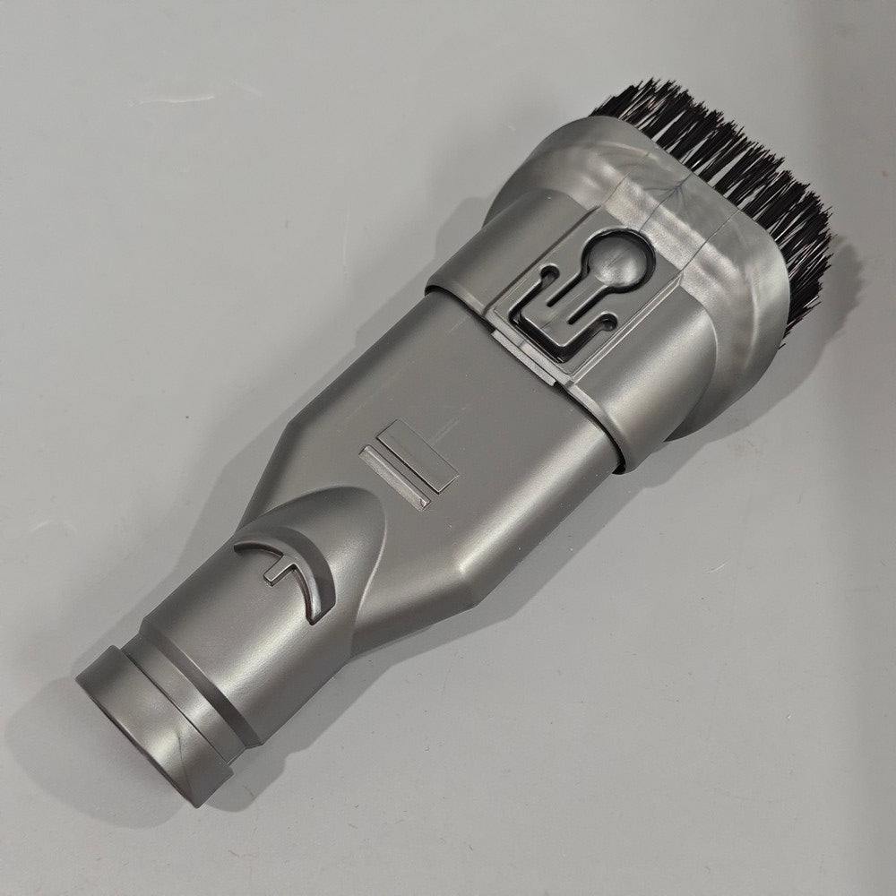 Gray grooming tool with bristle head on a light gray background