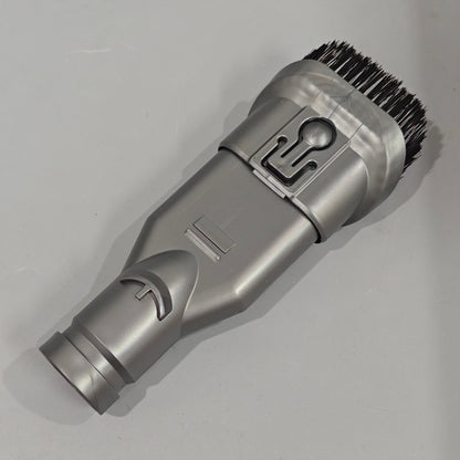 Gray grooming tool with bristle head on a light gray background