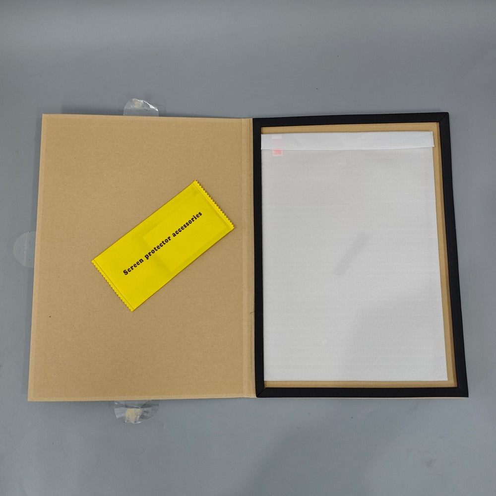 Open box containing a screen protector with a yellow label on a gray background